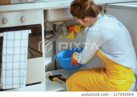 DIY Plumbing: Woman Catching Leaks 127892664