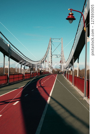 Suspension Pedestrian Bridge with Bicycle Lane under Clear Blue Sky 127893005