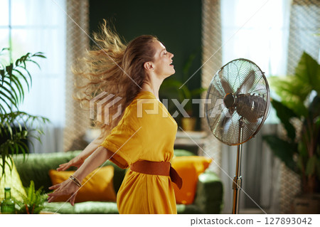 Blonde Woman Enjoying Vintage Fan Breeze 127893042