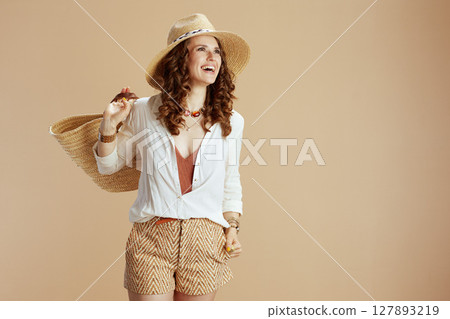 smiling housewife in blouse and shorts against beige smiling housewife in blouse and shorts against beige 127893219