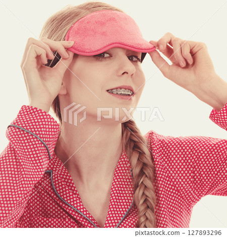 Sleepy woman wearing pink eye band 127893296