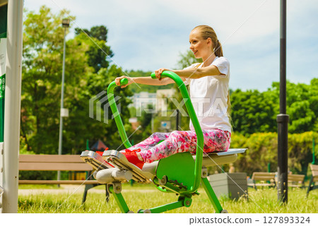 Girl doing legs exercise at outdoor gym area 127893324