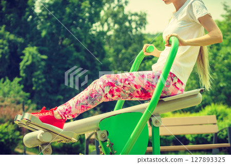 Girl doing legs exercise at outdoor gym area 127893325