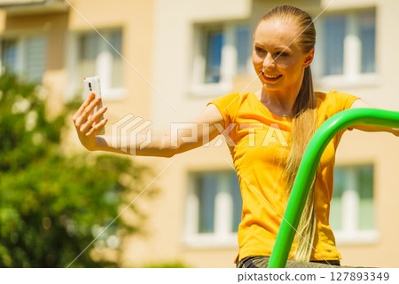 Girl doing exercises outdoor, taking selfie 127893349