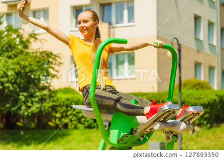 Girl doing exercises outdoor, taking selfie 127893350