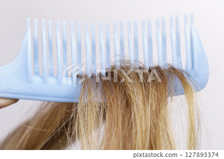 Blonde woman with her damaged dry hair. 127893374