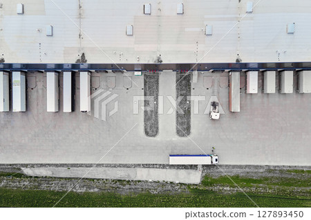 Top view of large modern warehouse with loading docks and trailers Top view of large modern warehouse with loading docks and trailers 127893450