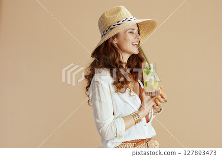 smiling stylish woman in blouse and shorts isolated on beige 127893473