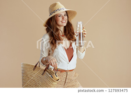 smiling stylish woman in blouse and shorts isolated on beige 127893475