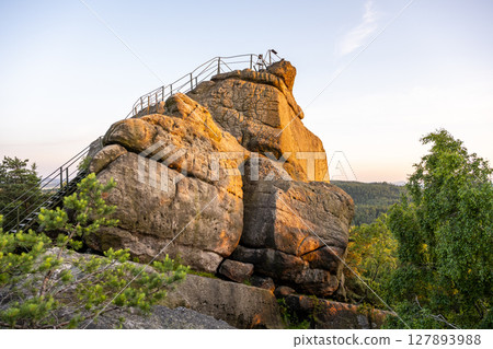 As the sun sets over the Lusatian Mountains, the sandstone Popov Cliffs glow warmly. Visitors can enjoy the beautiful views and explore the rocky terrain during this tranquil evening. As the sun sets over the Lusatian Mountains, the sandstone Popov Cliffs glow warmly. Visitors can enjoy the beautiful views and explore the rocky terrain during this tranquil evening. 127893988