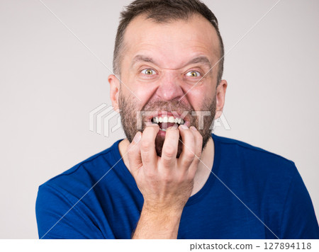 Man biting his nails 127894118