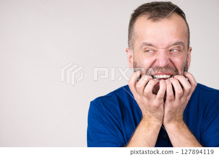 Man biting his nails Man biting his nails 127894119