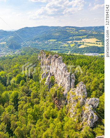 Panoramic view of the dry rocks of Suche skaly in Bohemian Paradise, Czechia. The sandstone formations rise dramatically from the lush green forest, creating a breathtaking landscape. Panoramic view of the dry rocks of Suche skaly in Bohemian Paradise, Czechia. The sandstone formations rise dramatically from the lush green forest, creating a breathtaking landscape. 127894142
