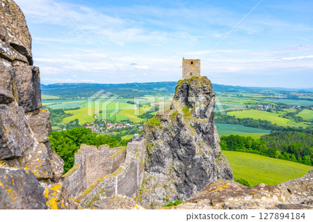 Panna Tower rises above the rugged landscape of Trosky Castle Ruins, surrounded by lush green hills and valleys. This historical site offers stunning views of the Bohemian Paradise region. 127894184
