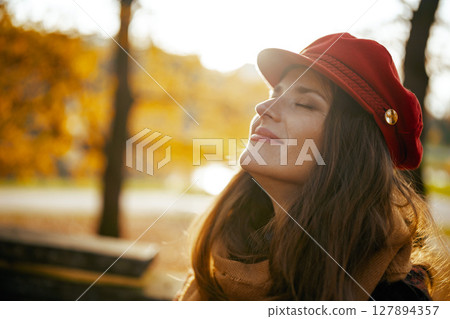 relaxed modern woman in red hat with scarf 127894357
