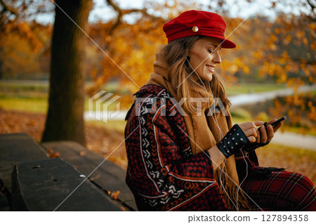 smiling modern 40 years old woman in red hat with headphones 127894358