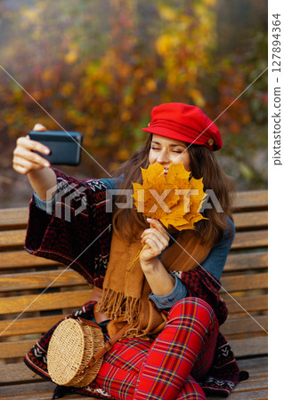 woman having online meeting while sitting on bench in city park woman having online meeting while sitting on bench in city park 127894364
