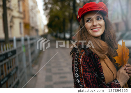 smiling stylish woman in red hat with autumn leafs smiling stylish woman in red hat with autumn leafs 127894365