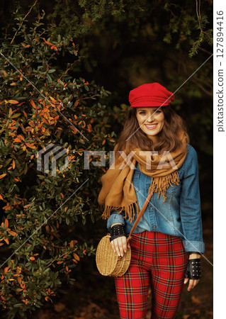 Portrait of smiling elegant female in jeans shirt and red hat Portrait of smiling elegant female in jeans shirt and red hat 127894416