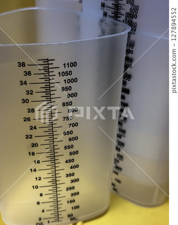 Close-Up of Graduated Plastic Measuring Cylinders in Healthcare Setting 127894552