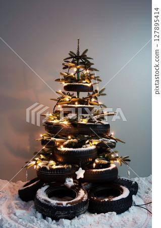Christmas tree made of car tires and wheels on grey background with copy space 127895414