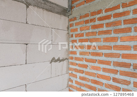 Two different construction wall materials lightweight concrete blocks and red bricks 127895468