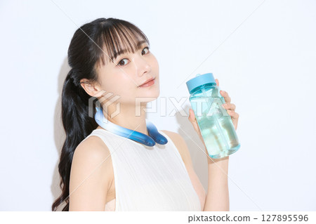 一位年輕女子採取措施抵禦高溫的肖像 一位年輕女子採取措施抵禦高溫的肖像 127895596