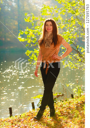 Woman walking through park in fall 127895763