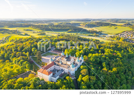 Holy Mountain in Pribram stands majestically, surrounded by lush greenery in spring. This Baroque complex attracts pilgrims seeking spiritual solace and stunning views of the countryside. Holy Mountain in Pribram stands majestically, surrounded by lush greenery in spring. This Baroque complex attracts pilgrims seeking spiritual solace and stunning views of the countryside. 127895999
