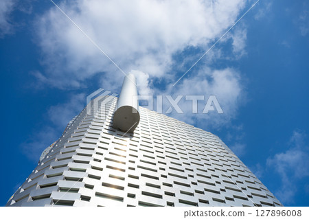 Amager Bakke in Copenhagen combines innovative waste-to-energy technology with recreational areas. Visitors enjoy leisure activities amidst its striking architecture under a clear sky. Amager Bakke in Copenhagen combines innovative waste-to-energy technology with recreational areas. Visitors enjoy leisure activities amidst its striking architecture under a clear sky. 127896008