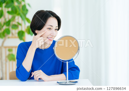 Middle-aged woman's beauty looking in the mirror 127896634