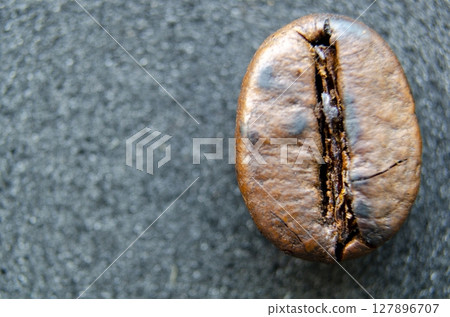 Microphotography of isolated coffee bean displaying crisp roast detail and a center groove with customizable space for text 127896707