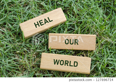 Heal Our World text on wooden blocks, symbolizing a hopeful message to restore environmental balance. Earth recovery concept Heal Our World text on wooden blocks, symbolizing a hopeful message to restore environmental balance. Earth recovery concept 127896714