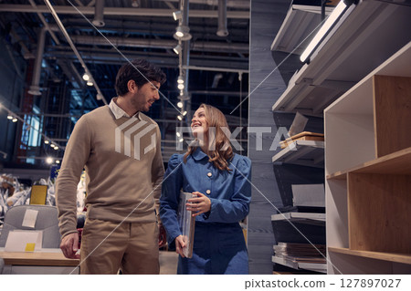 Loving couple enthusiastically shopping for stylish furniture in a contemporary modern store 127897027