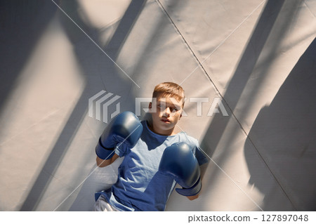 High above view on teenage boy lying on boxing ring floor High above view on teenage boy lying on boxing ring floor 127897048