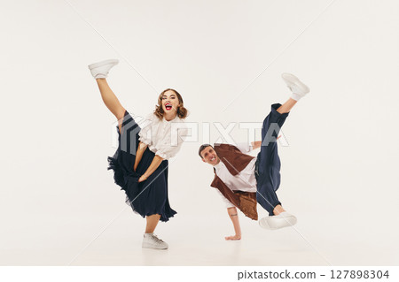 Energetic lindy hop dancers in mid-kick motion showcasing retro style and lively expression Energetic lindy hop dancers in mid-kick motion showcasing retro style and lively expression 127898304