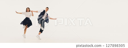 Dynamic duo performing lindy hop dance with lively retro flair against minimalist backdrop. Banner Dynamic duo performing lindy hop dance with lively retro flair against minimalist backdrop. Banner 127898305