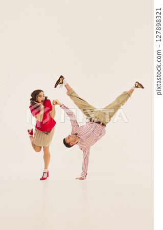 Dynamic lindy hop duo performing energetic retro dance move Dynamic lindy hop duo performing energetic retro dance move 127898321