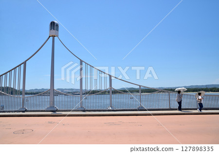 Two people crossing a bridge at Yokohama Seaside Park Two people crossing a bridge at Yokohama Seaside Park 127898335