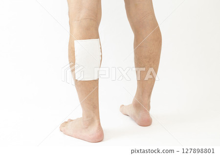 A man's leg with a compress on it, white background 127898801