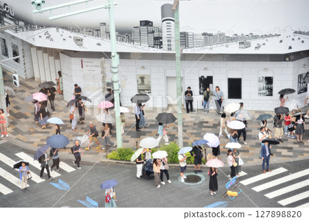 雨中的銀座四丁目步行街上，人們撐著傘行走 127898820