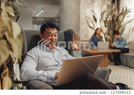 A professional man in a virtual meeting with his laptop, blending work and lifestyle 127899511
