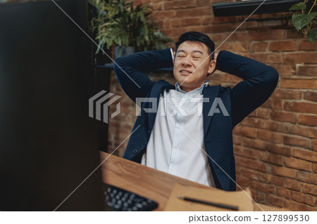 A Relaxed Professional at Work, achieving a balanced and productive atmosphere daily 127899530