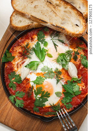 Portion of shakshuka breakfast with eggs Portion of shakshuka breakfast with eggs 127900175