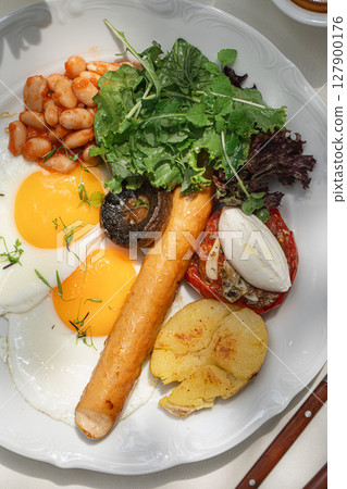 Portion of breakfast with sausage and fried eggs 127900176