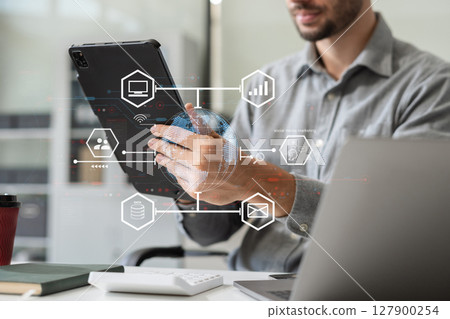 Social media icons screen of businessman with smartphone and laptop computer at office. Social media icons screen of businessman with smartphone and laptop computer at office. 127900254