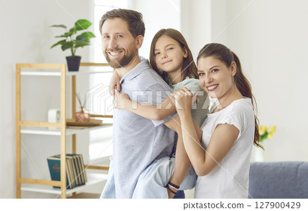 Family portrait of happy Caucasian young couple and their preteen daughter. 127900429