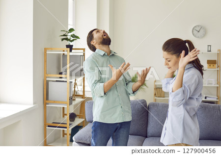 Upset young couple quarreling in the living room at home. Relationship and divorce concept. 127900456
