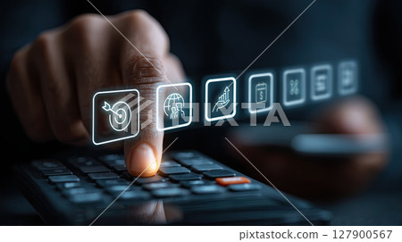 Hand pressing calculator with digital icons representing business analytics, finance, and technology. image conveys innovation and strategy 127900567
