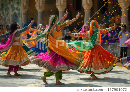 Indian women wearing colorful traditional clothing while dancing outdoors during a festival 127901072